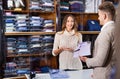 Woman seller assisting man in choosing shirt in menÃ¢â¬â¢s cloths s Royalty Free Stock Photo